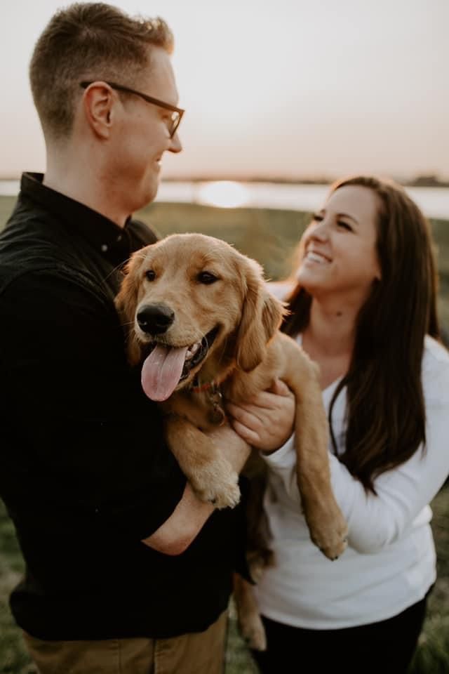 A couple holding their Golden Retriever puppy on go-home day
